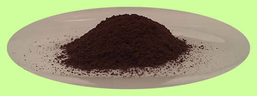 A pile of finely ground Chaga powder on a plate, made from wild-harvested Chaga mushrooms